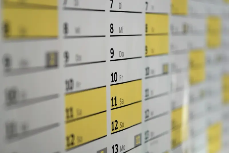 Calendário de parede com dias marcados em amarelo, lembrando os prazos das obrigações do MEI