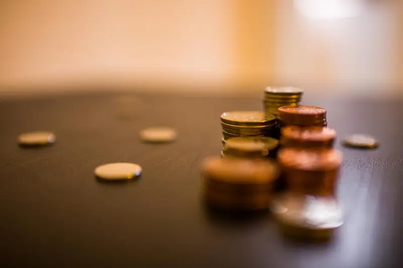 Pilhas de moedas sobre uma mesa de madeira